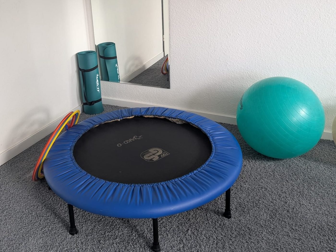 Therapieraum für Bewegung und Wahrnehmung mit Trampolin, Gymnastikball und großem Spiegel